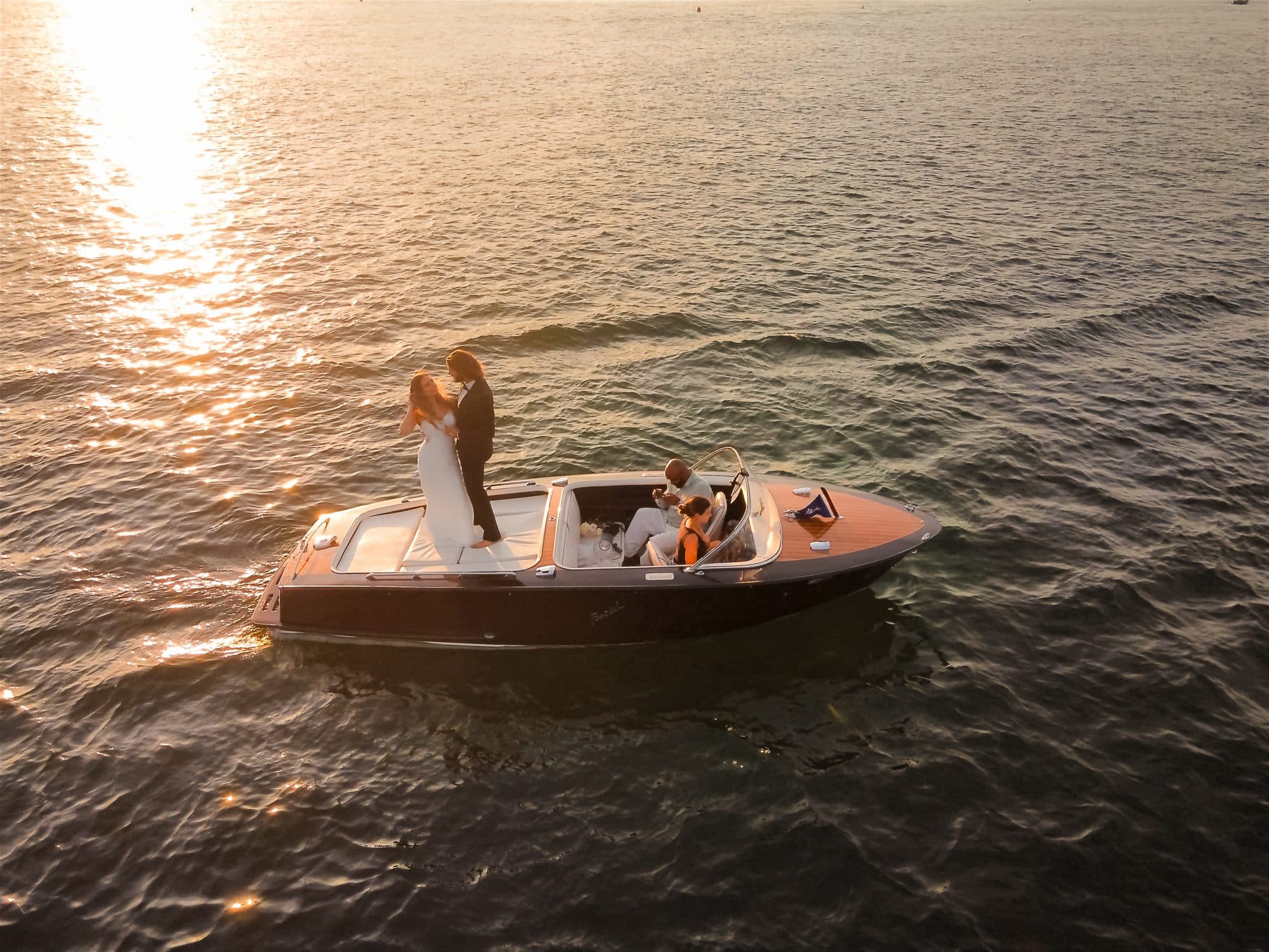 Vue aérienne du bateau d'acajou GenevaBoats sur le lac Léman au coucher du soleil, les mariés enlacés à la proue — Genève
