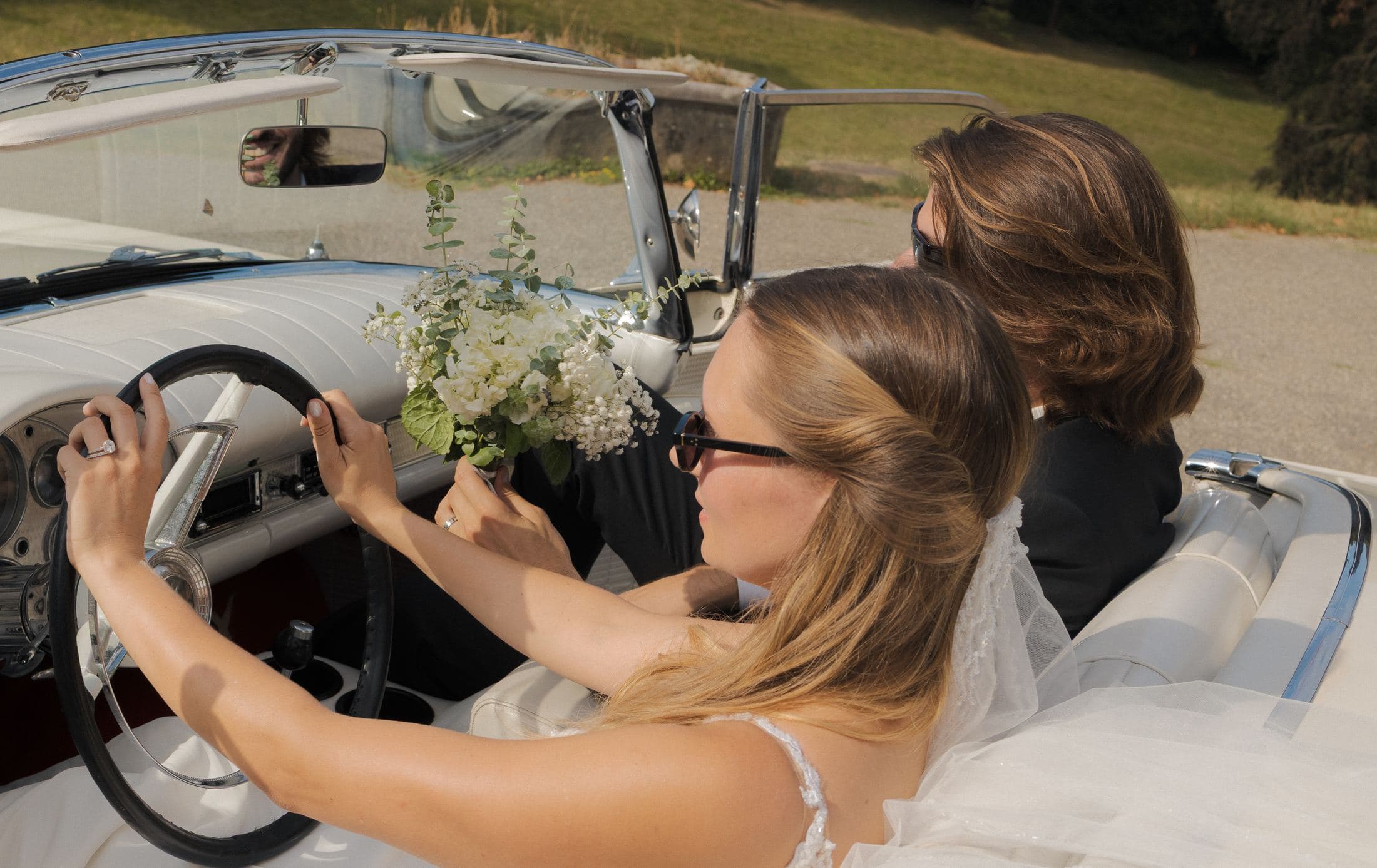 Les mariés à bord de la Ford Thunderbird 1957 de collection, bouquet à la main — Domaine de Penthes, Genève